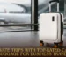 White hard-shell top-rated cabin luggage for business travel positioned in an airport terminal with a plane in the background.